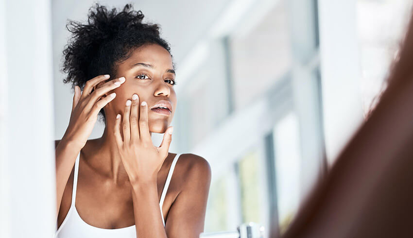 Woman checking her skin in the mirror